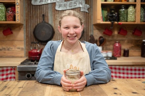 A young girl with a jar of homemade sugar scrub.