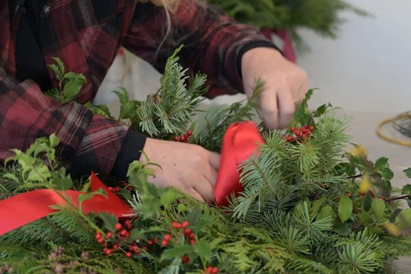 A woman making a holiday wreath.